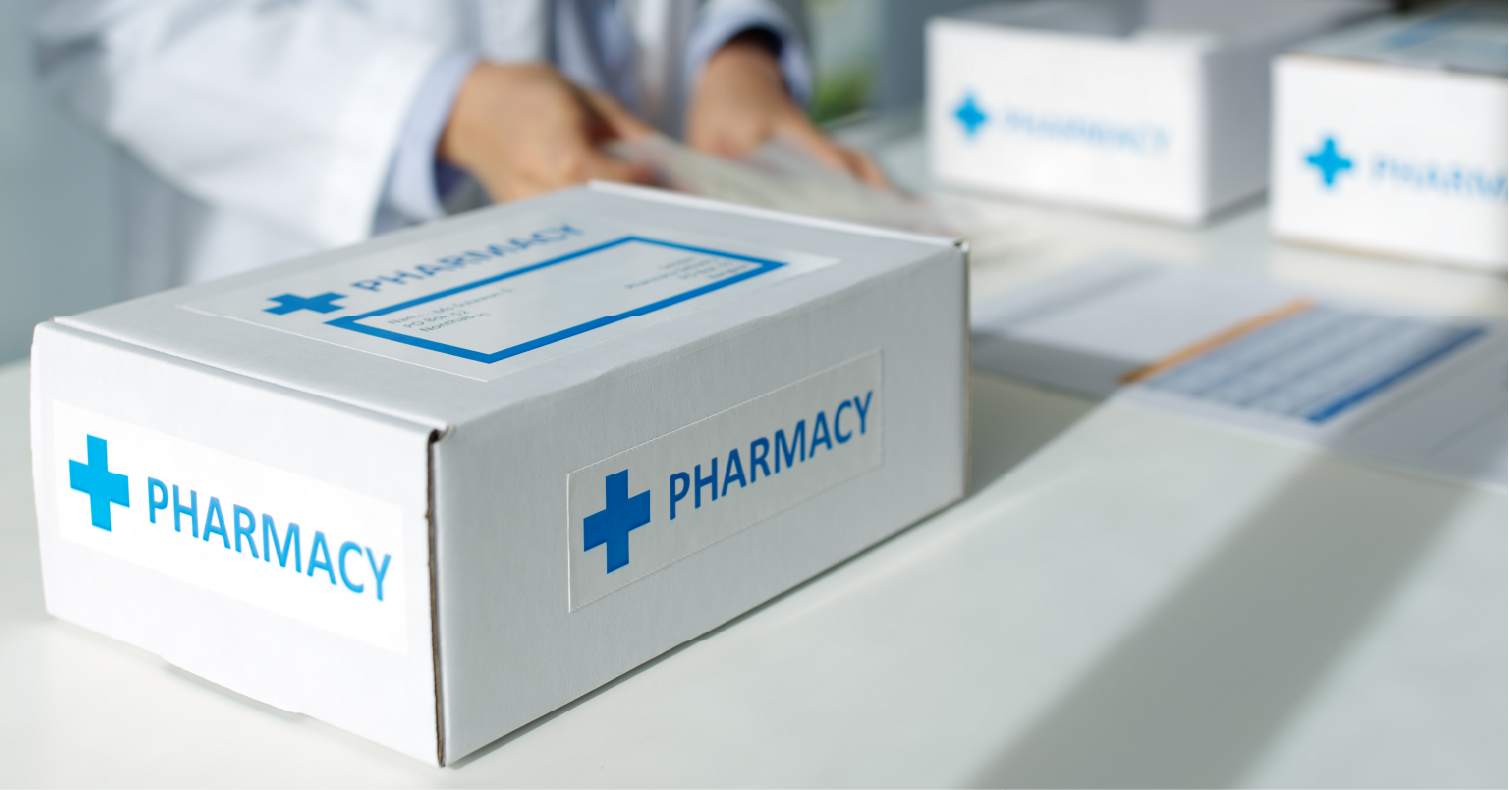 The pharmacy box is on the table with the person behind