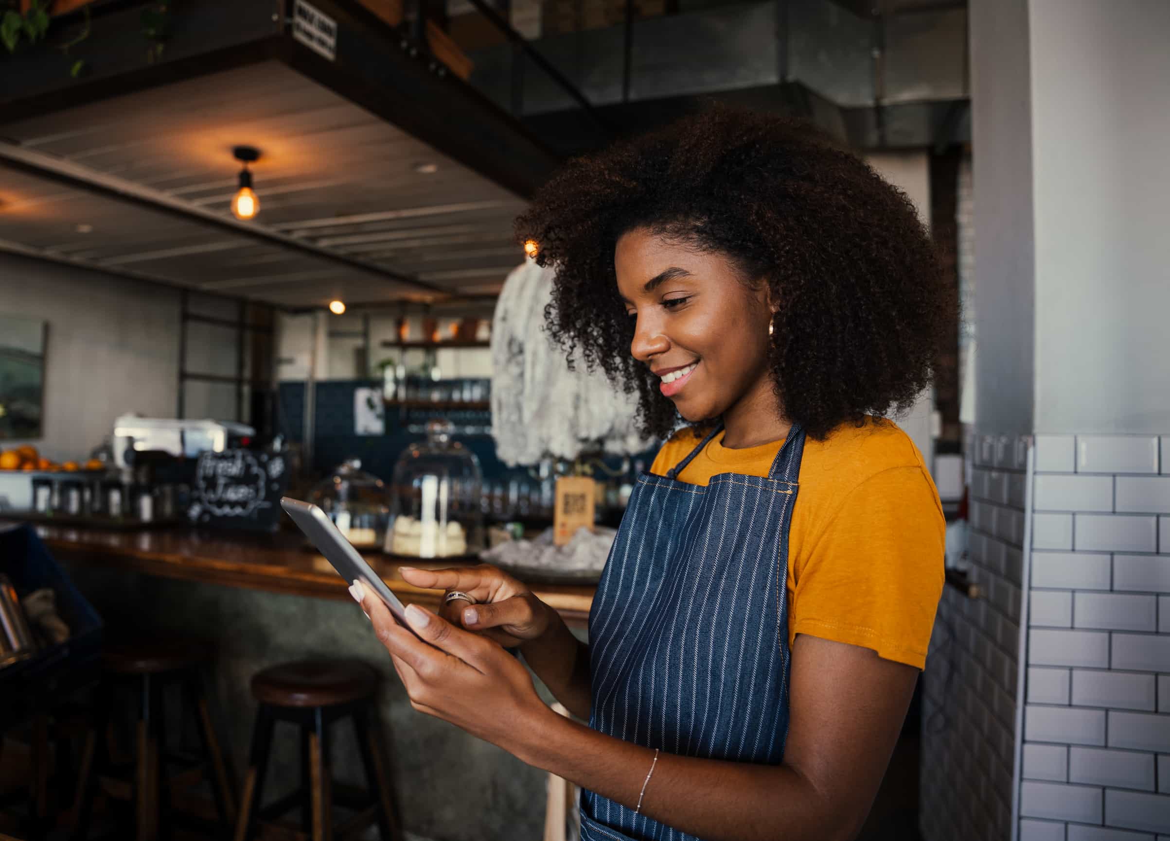 Restaurant employee checking smartphone to manage sales data
