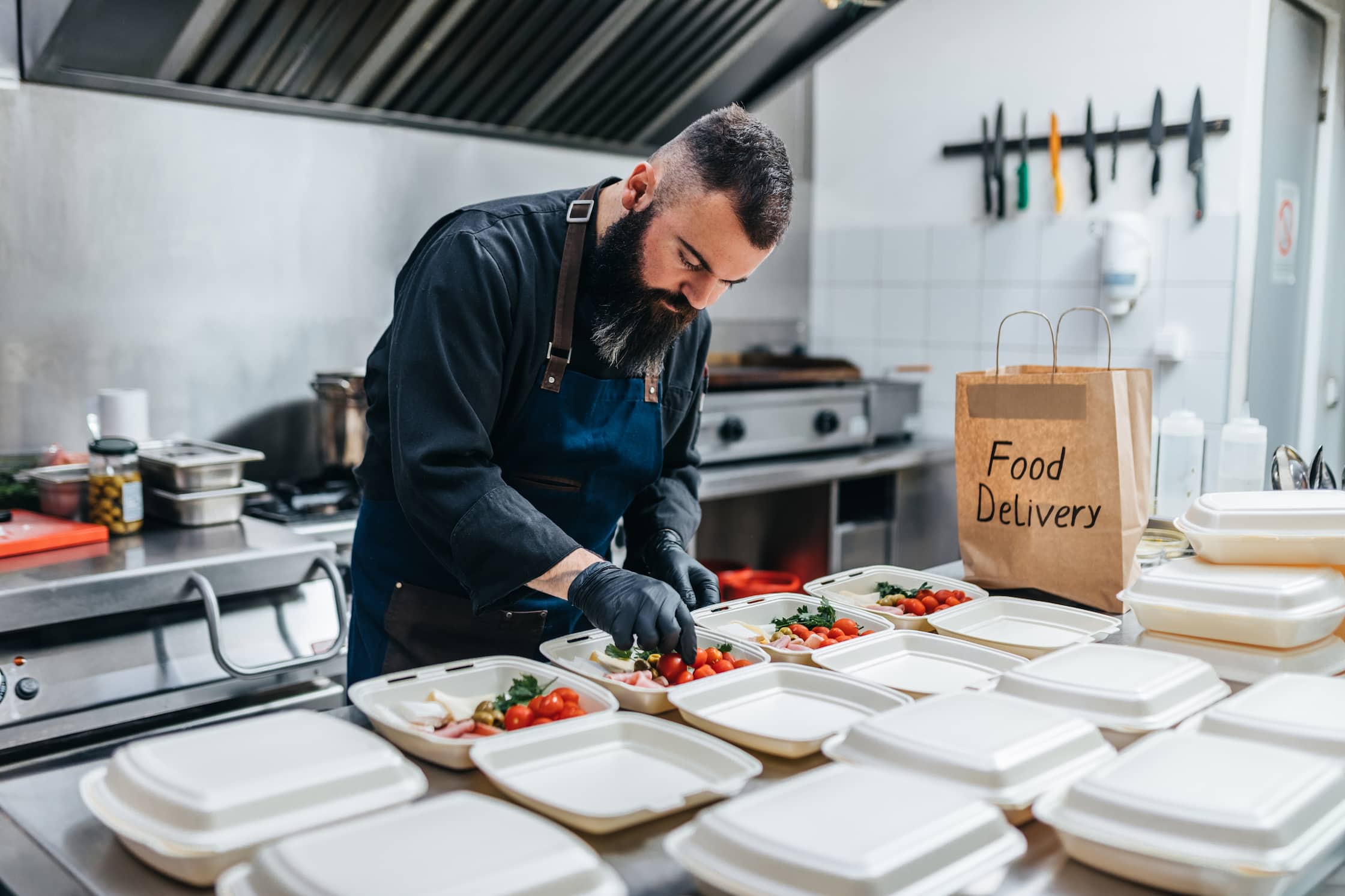 Man preparing food in a restaurant for delivery service.